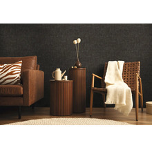 Obývací pokoj s pohovkou, křeslem a příručními stolky před tmavou stěnou