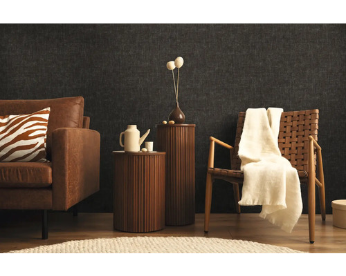 Obývací pokoj s pohovkou, křeslem a příručními stolky před tmavou stěnou