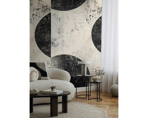 Obývací pokoj s pohovkou, konferenčním stolkem a tapetou s abstraktním kruhovým vzorem.