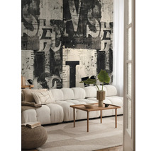 Obývací pokoj s pohovkou, dřevěným stolem a tapetou s novinovým designem