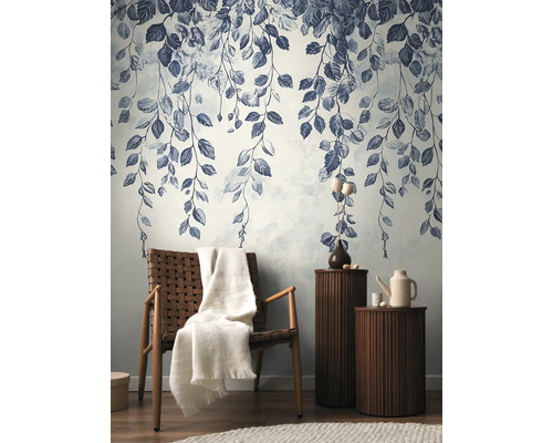 Dekorativní tapeta se vzorem listů v stylovém obývacím pokoji s křeslem a odkládacími stolky.
