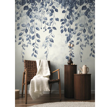 Dekorativní stěna se vzorem listů, křeslo s dekou a příruční stolky v obývacím pokoji.