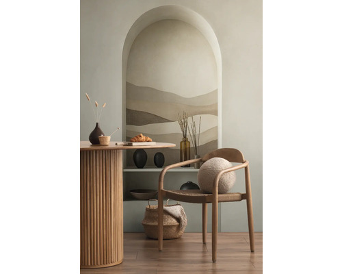 Světlá místnost s jídelním stolem, dřevěnou židlí a dekorativními prvky na polici ve výklenku