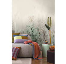 Obývací pokoj s pohovkou, polštáři, dekou a tapetou s motivem rostlin