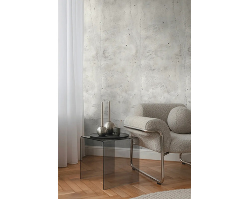 Interiér s betonovou tapetou, křeslem a odkládacím stolkem