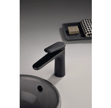 Černá umyvadlová baterie vedle umyvadla, mýdla a ručníku