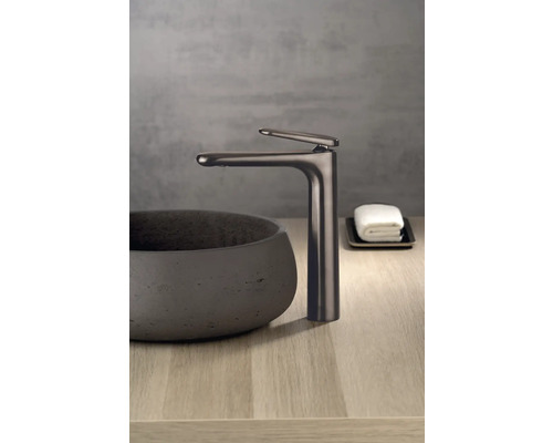 Umyvadlová baterie vedle umyvadla na desku na dřevěném povrchu