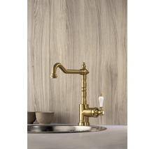 Zlatá kuchyňská baterie s bílou rukojetí namontovaná v umyvadle