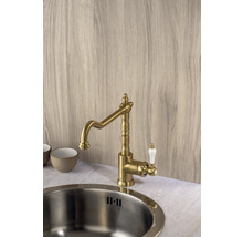 Mosazná kuchyňská baterie s bílou rukojetí vedle dřezu