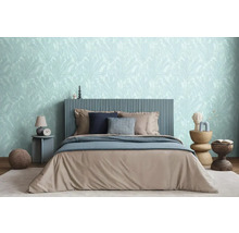 Ložnice s postelí, nočním stolkem a květinovou tapetou