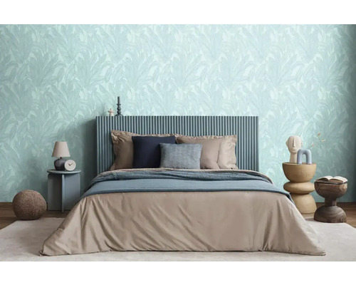 Ložnice s postelí, nočním stolkem a květinovou tapetou