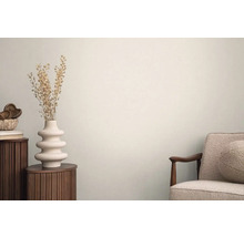 Světlý interiér s odkládacím stolem, vázou se sušenými květinami a křeslem