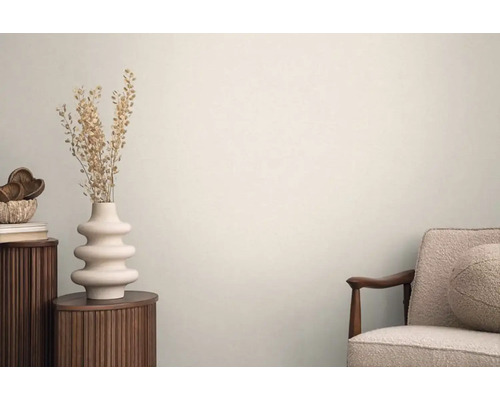 Světlý interiér s odkládacím stolem, vázou se sušenými květinami a křeslem