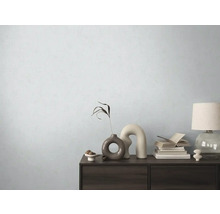 Dekorativní komoda s vázami, knihami a lampou před světlou stěnou