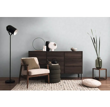 Obývací pokoj s komodou, křeslem, stojací lampou a dekorativními prvky pro útulnou atmosféru