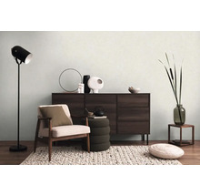 Obývací pokoj s křeslem, komodou, stojací lampou a dekorací pro útulnou atmosféru.