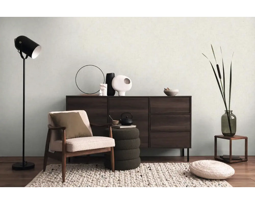 Obývací pokoj s křeslem, komodou, stojací lampou a dekorací pro útulnou atmosféru.