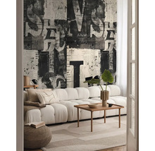 Obývací pokoj s pohovkou, konferenčním stolkem a tapetou s novinovým potiskem