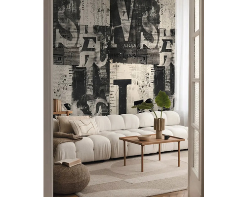 Obývací pokoj s pohovkou, konferenčním stolkem a tapetou s novinovým potiskem