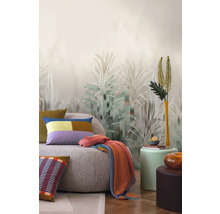 Návrh interiéru s pohovkou, polštáři, dekou a dekorativní nástěnnou tapetou s rostlinnými motivy.