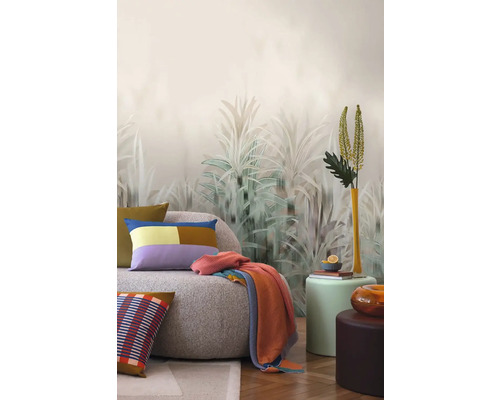 Návrh interiéru s pohovkou, polštáři, dekou a dekorativní nástěnnou tapetou s rostlinnými motivy.