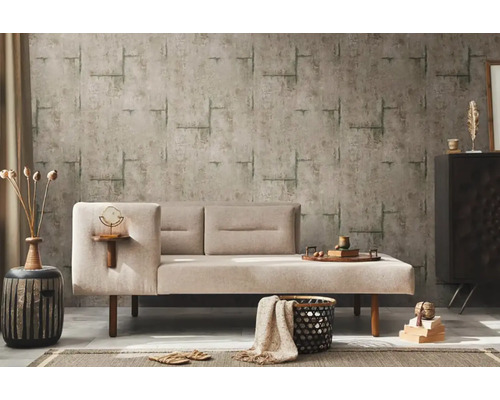 Obývací pokoj s béžovou pohovkou, vzorovanou tapetou a dekorativními prvky pro útulnou atmosféru.