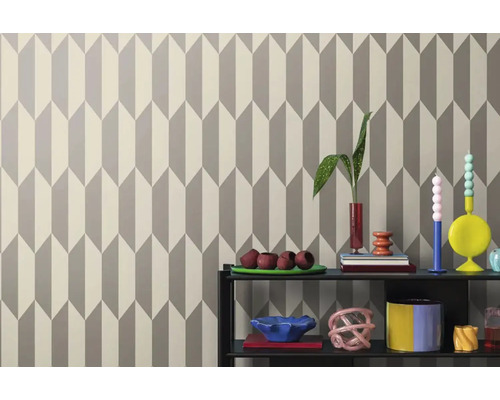 Stěna s geometrickou tapetou a dekorativními předměty na polici