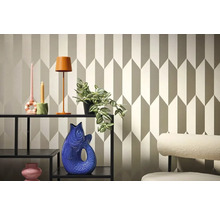 Dekorativní pokoj s geometrickou tapetou, regálem, lampou a dekorativními předměty