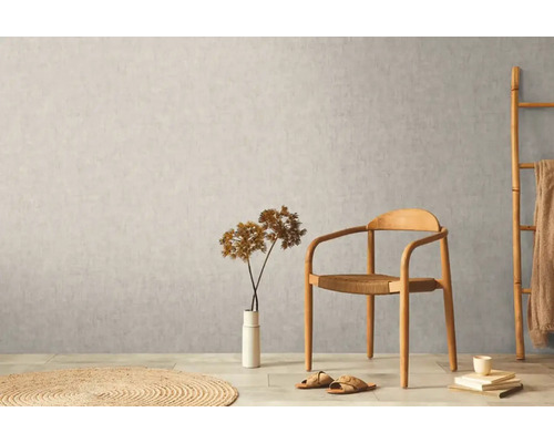 Světlý interiér s dřevěnou židlí, dekorací a textilem