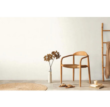 Světlá místnost s dřevěnou židlí, kobercem, dekorací a žebříkem