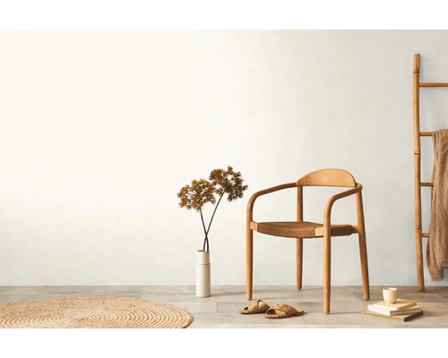 Světlá místnost s dřevěnou židlí, kobercem, dekorací a žebříkem