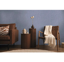 Obývací pokoj s pohovkou, židlí a odkládacími stolky před modrou stěnou