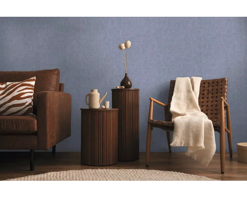 Obývací pokoj s pohovkou, židlí a odkládacími stolky před modrou stěnou