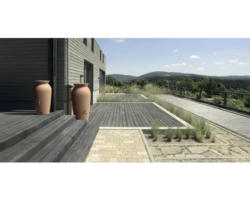 Dvě nádrže na dešťovou vodu v zahradě rodinného domu.