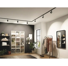 Moderní šatna s černým kolejnicovým systémem a variabilními bodovými světly pro flexibilní osvětlení.