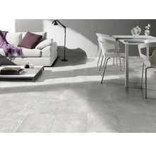 Světlý obývací pokoj s pohovkou, stolem, židlí a podlahovými dlaždicemi