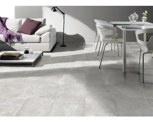 Světlý obývací pokoj s pohovkou, stolem, židlí a podlahovými dlaždicemi