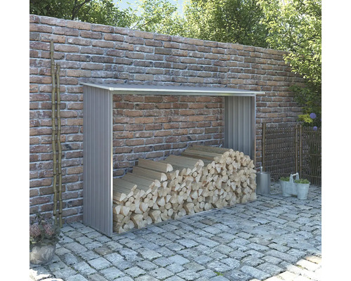 Sklad dřeva s palivovým dřívím před cihlovou zdí