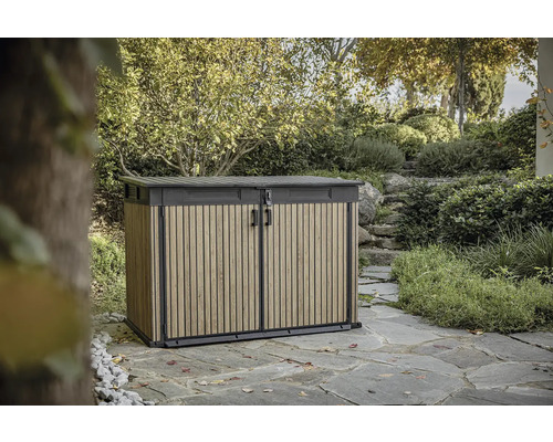 Zahradní skříň s dřevěným efektem venku pro uložení zahradního nářadí a příslušenství.