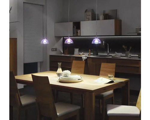 Jídelní stůl se židlemi a závěsnými svítidly v moderním kuchyňském designu.