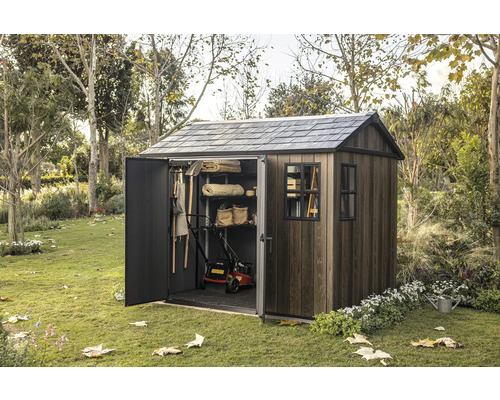 Zahradní kůlna s otevřenými dveřmi na zahradě, plná zahradního nářadí