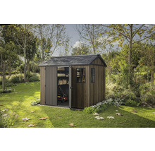 Zahradní scéna s dřevěným zahradním domkem s částečně otevřenými posuvnými dveřmi a oknem