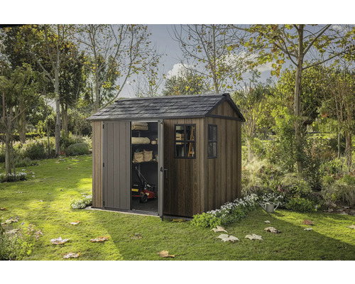 Zahradní scéna s dřevěným zahradním domkem s částečně otevřenými posuvnými dveřmi a oknem