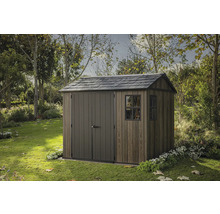 Dřevěný zahradní domek s dvoukřídlými dveřmi a oknem na zahradě.