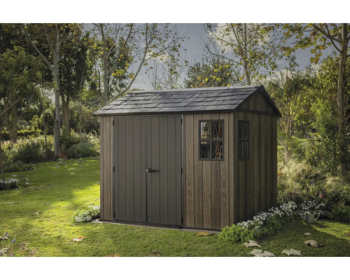 Dřevěný zahradní domek s dvoukřídlými dveřmi a oknem na zahradě.