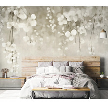 Ložnice s fototapetou s motivem listů nad dřevěnou postelí