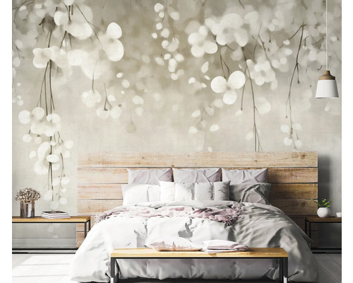 Ložnice s fototapetou s motivem listů nad dřevěnou postelí