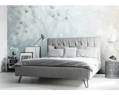 Ložnice s postelí, nočním stolkem a květinovou tapetou