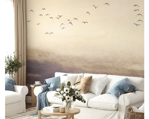 Obývací pokoj s tapetou zobrazující krajinu s ptáky, pohovkou a dekorací
