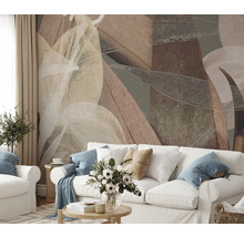 Obývací pokoj s abstraktním listovým vzorem na zdi za bílou pohovkou.